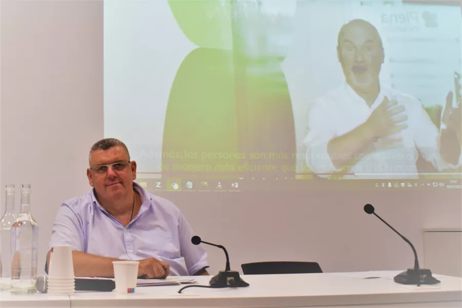 El director de Support-Girona fent de ponent amb una projecció de vídeo darrere