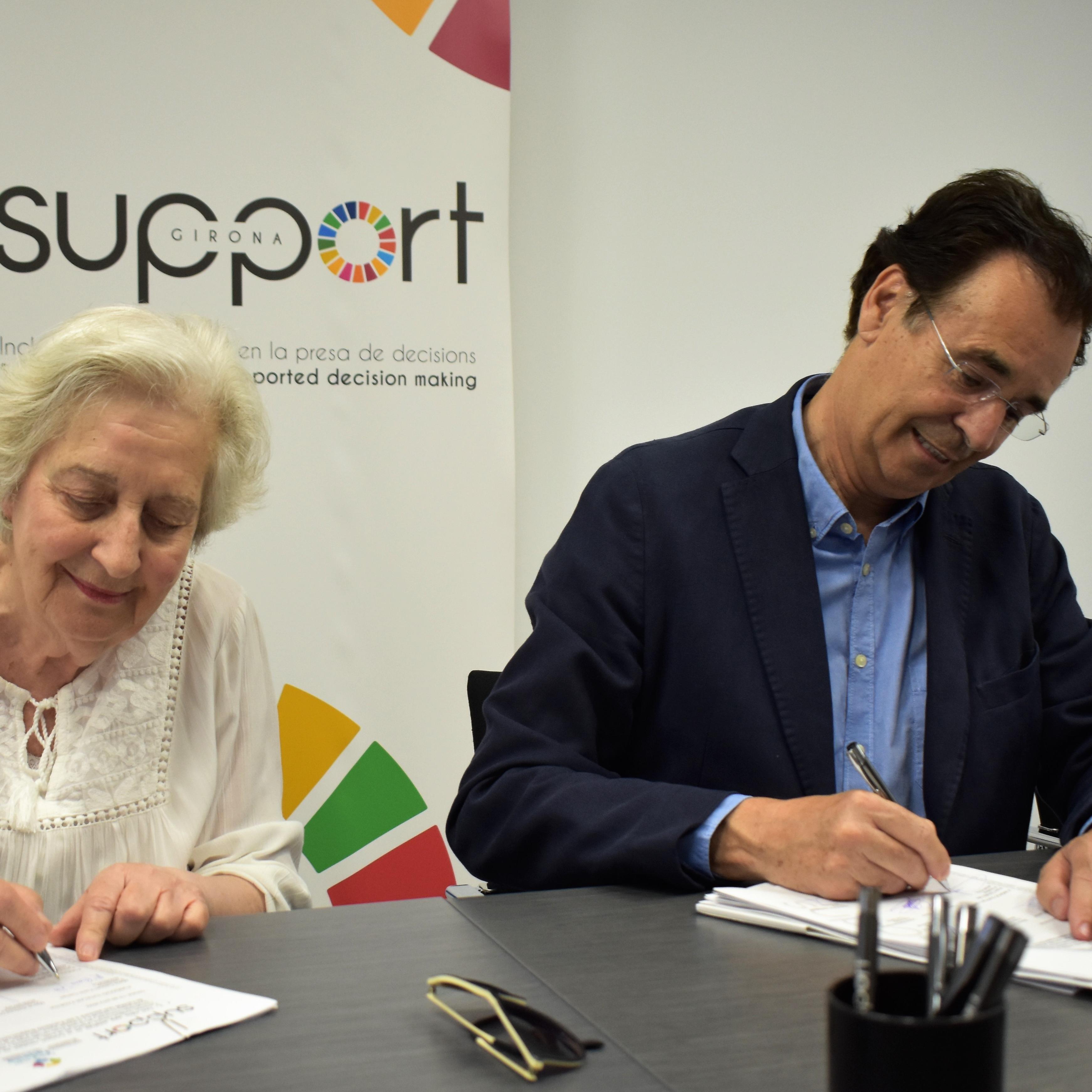 Una dona i un home signant. Són la presidenta de la Fundació Tutelar Fadesia i el president de Support-Girona
