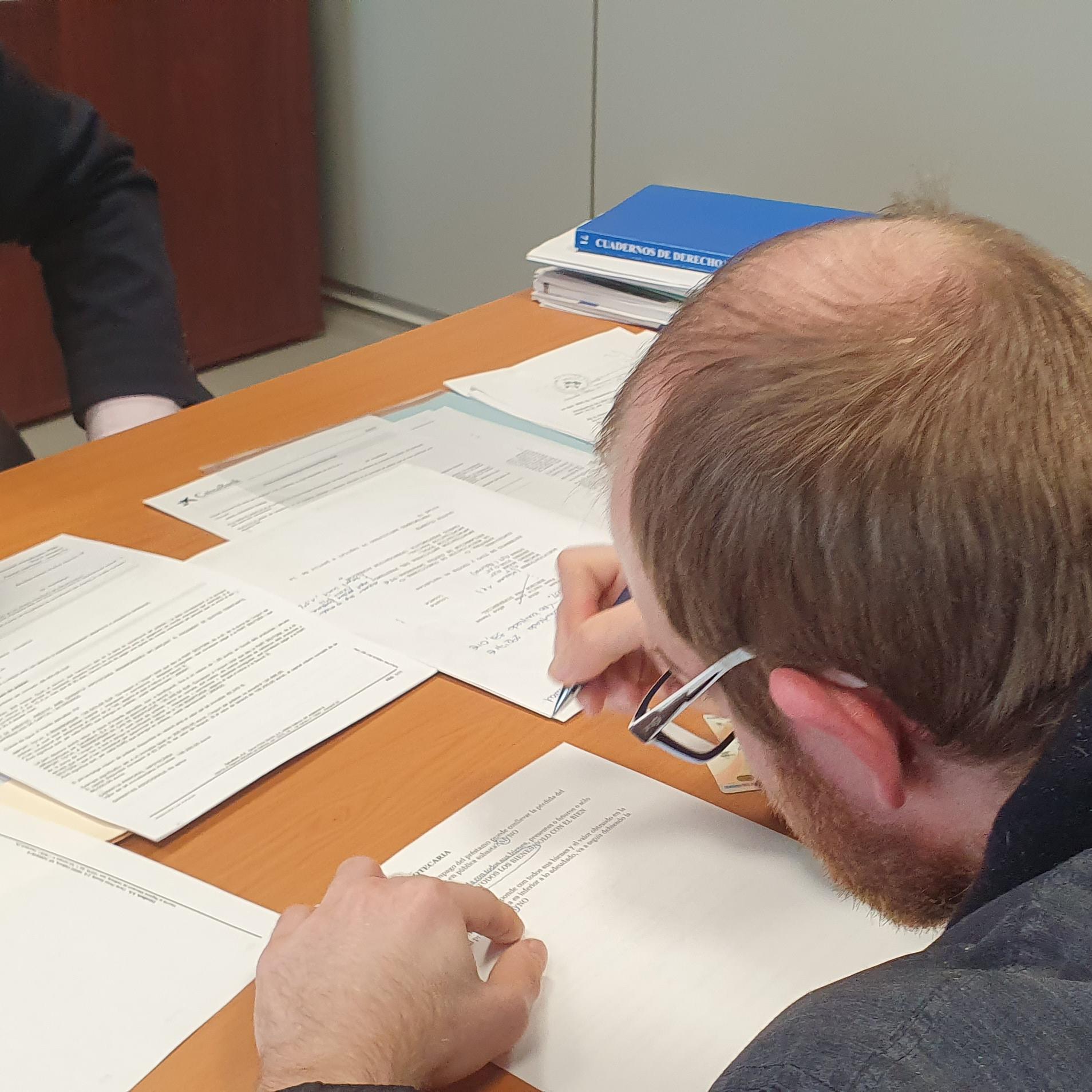 Una persona signant un document al notari