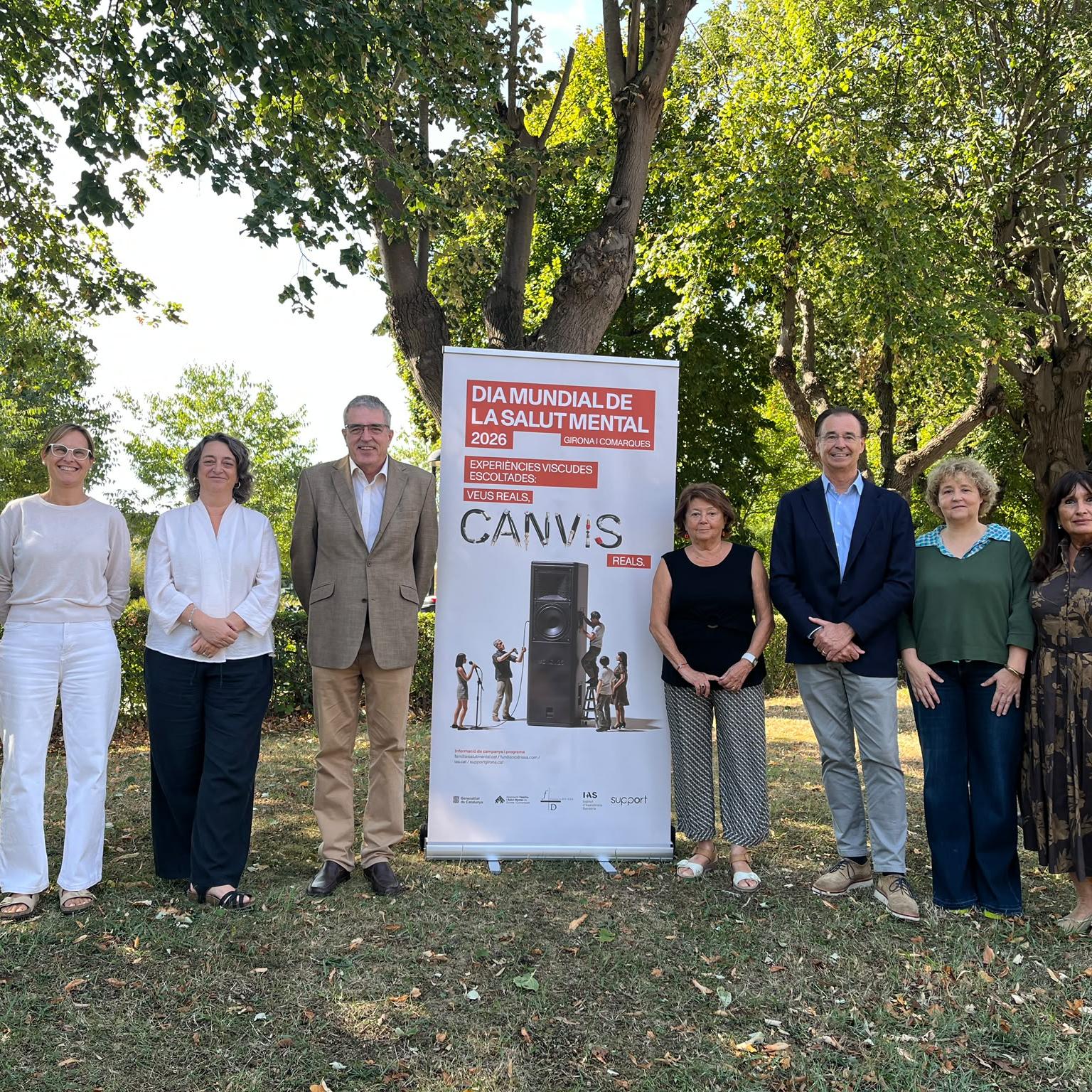 Persones amb la imatge de campanya en format de roll up