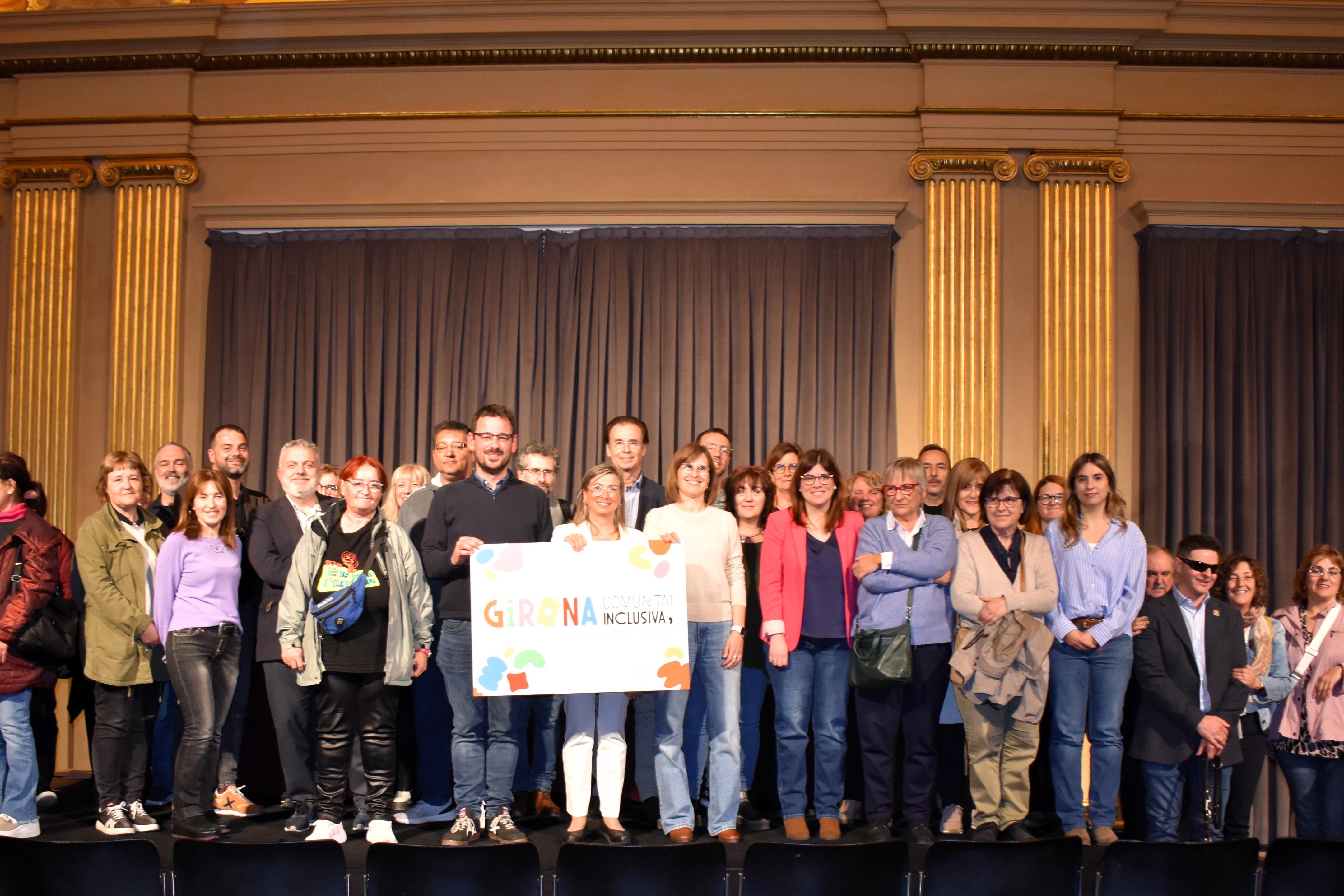 Representants de l'Espai Girona Comunitat Inclusiva, amb l'alcalde de Girona i regidors, mostrant la marca "Girona Ciutat inclusiva"