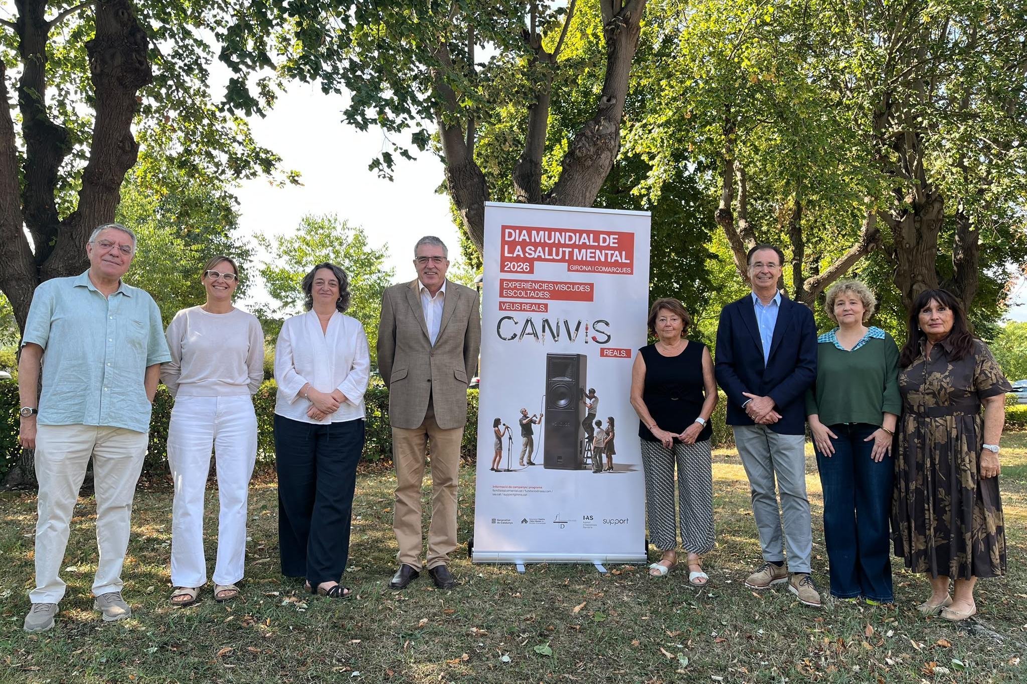 Persones amb la imatge de campanya en format de roll up